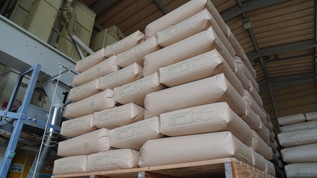 倉庫に高く積まれた米の袋。齋藤さんは「コシヒカリ」と「あいちのかおり」をメインに、「ゆうだい」「ミルキークイーン」、もち米「十五夜もち」などを栽培されている。  